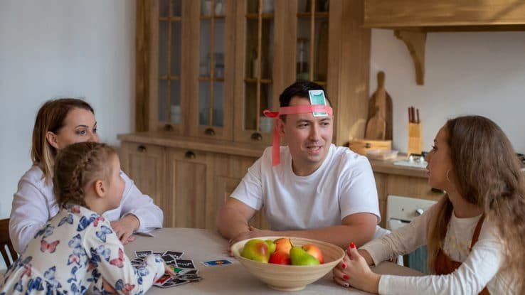 Family playing a game at the kitchen table