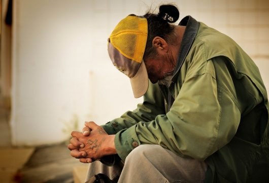 Man sitting outside of an outreach ministry building