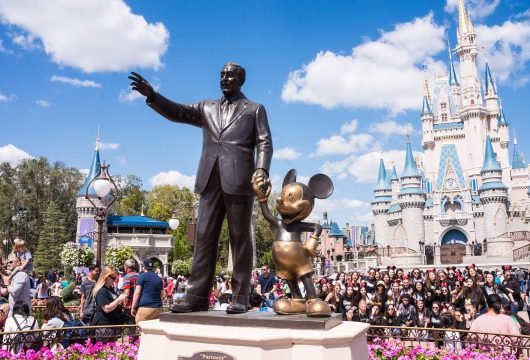 Walt Disney and Mickey Mouse statues at a Disney theme park