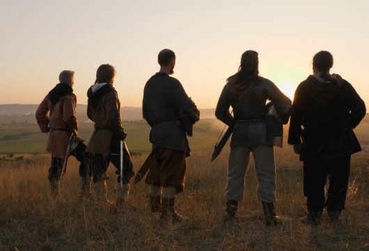 Group of warriors looking out at a battlefield