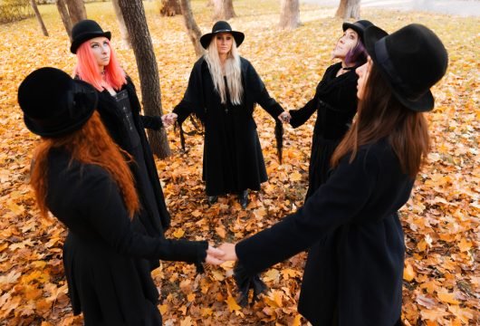 Witch coven meeting in a park during autumn